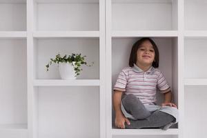 young boy posing on a shelf photo