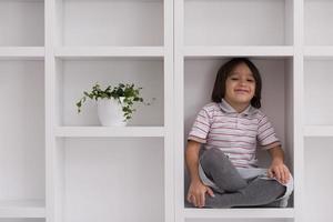 young boy posing on a shelf photo