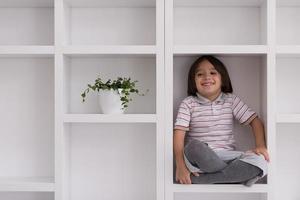 young boy posing on a shelf photo