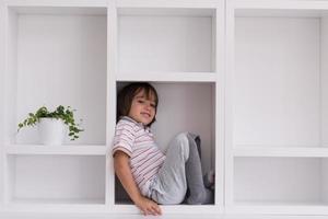 young boy posing on a shelf photo