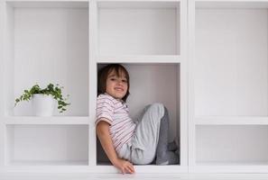 young boy posing on a shelf photo