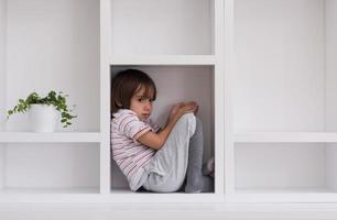 young boy posing on a shelf photo