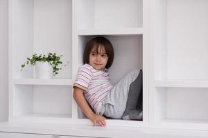 young boy posing on a shelf photo