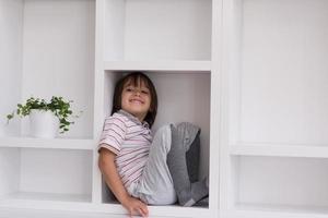 young boy posing on a shelf photo