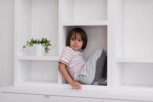 young boy posing on a shelf photo