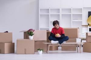 boy sitting on the table with cardboard boxes around him photo