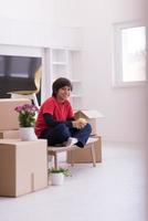 boy sitting on the table with cardboard boxes around him photo