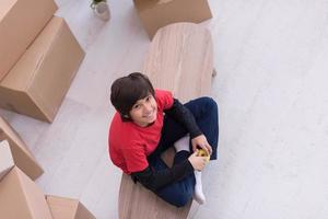 niño sentado en la mesa con cajas de cartón a su alrededor vista superior foto