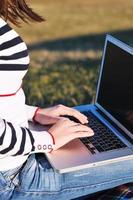 young teen girl work on laptop outdoor photo