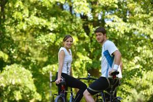 Happy couple riding bicycle outdoors photo