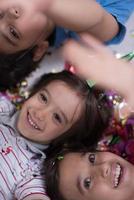 kids  blowing confetti while lying on the floor photo