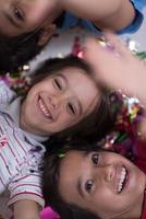 kids  blowing confetti while lying on the floor photo