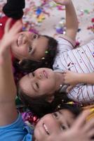 kids  blowing confetti while lying on the floor photo