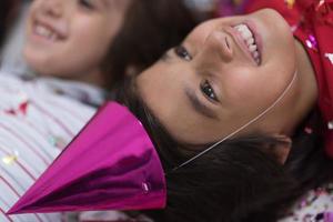 kids  blowing confetti while lying on the floor photo