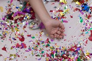 mano de niños con confeti en segundo plano. foto