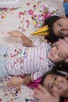 niños que soplan confeti mientras están acostados en el suelo foto