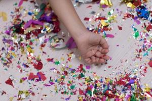 mano de niños con confeti en segundo plano. foto
