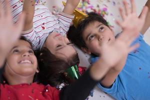 kids  blowing confetti while lying on the floor photo