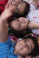 kids  blowing confetti while lying on the floor photo