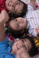 kids  blowing confetti while lying on the floor photo