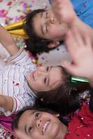 kids  blowing confetti while lying on the floor photo