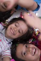 kids  blowing confetti while lying on the floor photo