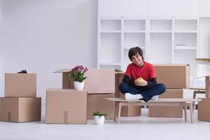 boy sitting on the table with cardboard boxes around him photo