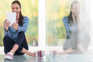 mujeres jóvenes que usan una tableta en el piso foto