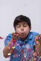 niño soplando confeti foto