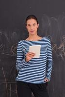 woman using tablet  in front of chalk drawing board photo