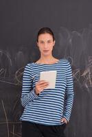 woman using tablet  in front of chalk drawing board photo