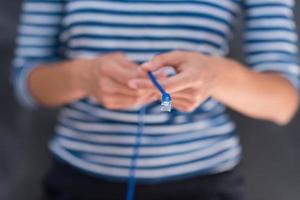 mujer sosteniendo un cable de internet frente a un tablero de dibujo de tiza foto