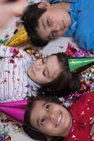 kids  blowing confetti while lying on the floor photo