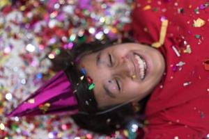 kid blowing confetti while lying on the floor photo