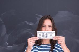 woman holding a banknote in front of chalk drawing board photo