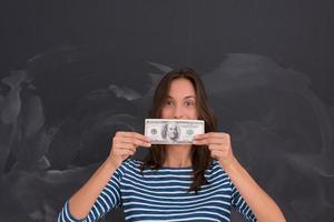 woman holding a banknote in front of chalk drawing board photo