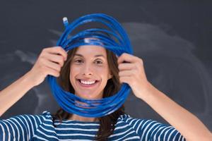 mujer sosteniendo un cable de internet frente a un tablero de dibujo de tiza foto