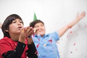 niños soplando confeti foto