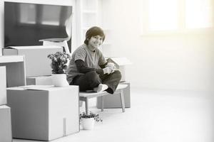 boy sitting on the table with cardboard boxes around him photo