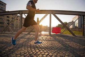 hombre corriendo por el puente en la mañana soleada foto