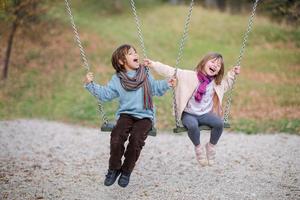 los niños se balancean en el parque foto