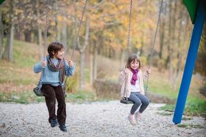 los niños se balancean en el parque foto