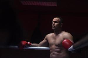 kick boxer resting on the ropes in the corner photo