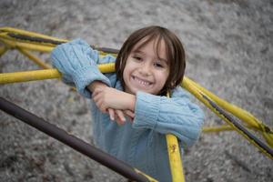 lindo niño divirtiéndose en el patio de recreo foto