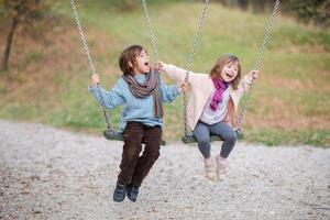 los niños se balancean en el parque foto