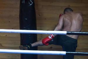 kick boxer training on a punching bag photo