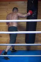 kick boxer training on a punching bag photo