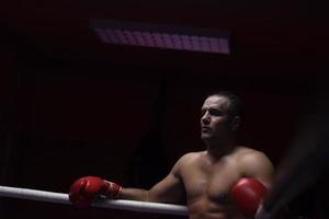 kick boxer resting on the ropes in the corner photo