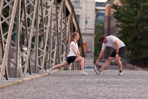 couple warming up and stretching before jogging photo