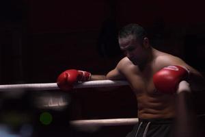 kick boxer resting on the ropes in the corner photo